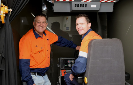 Greg Lee (standing) and Dave Palmer (in the seat) discuss the operation of the simulator.